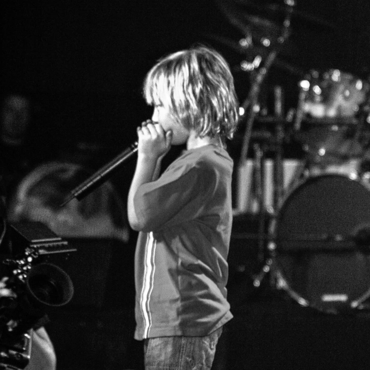 Jude as a kid, on stage with a microphone
